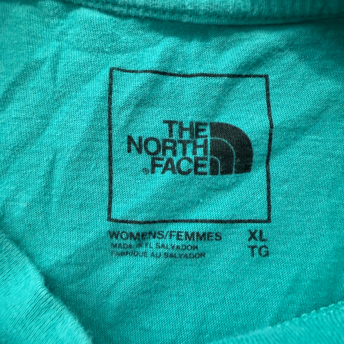 The North Face teal tee brand and size tag